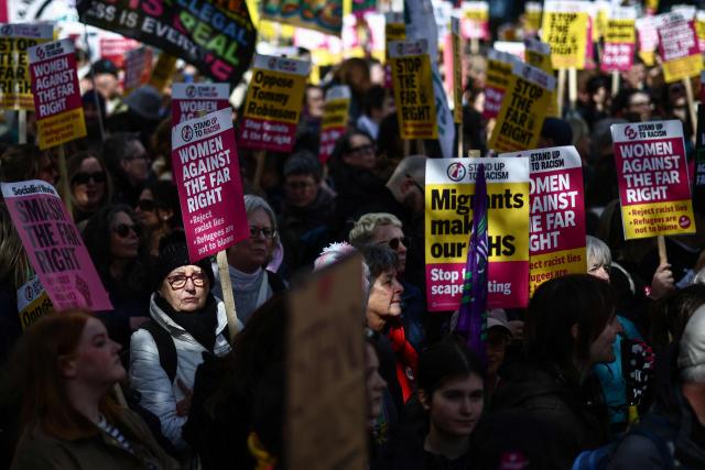Protesters holding placards and waving flags take part in a march against the far right, organised by the Together Alliance, in central London on March 28, 2026. (Photo by Henry NICHOLLS / AFP)