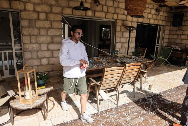 A resident assesses the damage at a house following a projectile strike in Eshtaol, near Beit Shemesh in central Israel, on March 28, 2026. The Middle East was sparked by joint US-Israeli strikes on Iran that triggered a wave of retaliatory missile and drone attacks against Israel and several other countries in the region. (Photo by AHMAD GHARABLI / AFP) / 