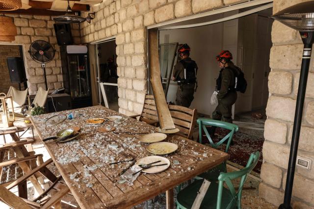 TOPSHOT - First responders assess the damage inside a house after a projectile strike in Eshtaol, near Beit Shemesh in central Israel, on March 28, 2026. The Middle East was sparked by joint US-Israeli strikes on Iran that triggered a wave of retaliatory missile and drone attacks against Israel and several other countries in the region. (Photo by AHMAD GHARABLI / AFP) / 