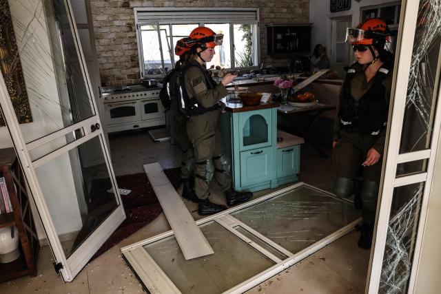 First responders assess the damage inside a house after a projectile strike in Eshtaol, near Beit Shemesh in central Israel, on March 28, 2026. The Middle East was sparked by joint US-Israeli strikes on Iran that triggered a wave of retaliatory missile and drone attacks against Israel and several other countries in the region. (Photo by AHMAD GHARABLI / AFP) / 