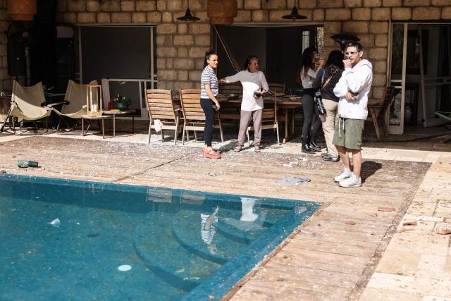 TOPSHOT - Residents assess the damage inside a house after a projectile strike in Eshtaol, near Beit Shemesh in central Israel, on March 28, 2026. The Middle East was sparked by joint US-Israeli strikes on Iran that triggered a wave of retaliatory missile and drone attacks against Israel and several other countries in the region. (Photo by AHMAD GHARABLI / AFP) / 