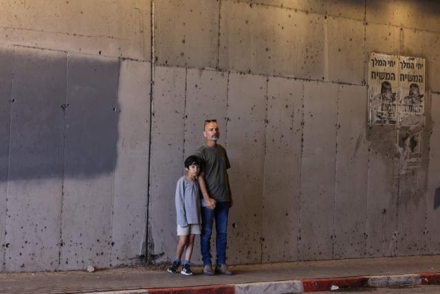 TOPSHOT - A man and a child take shelter inside a tunnel near Abu Ghosh as missile-warning sirens sound on March 28, 2026. The Middle East was sparked by joint US-Israeli strikes on Iran that triggered a wave of retaliatory missile and drone attacks against Israel and several other countries in the region. (Photo by AHMAD GHARABLI / AFP) / 