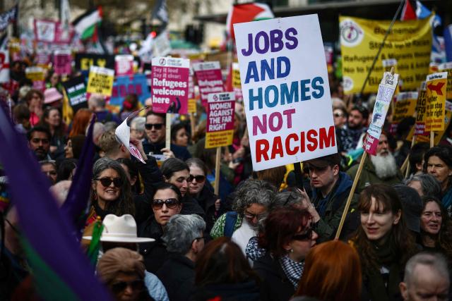 Protesters holding placards and waving flags take part in a march against the far right, organised by the Together Alliance, in central London on March 28, 2026. (Photo by Henry NICHOLLS / AFP)