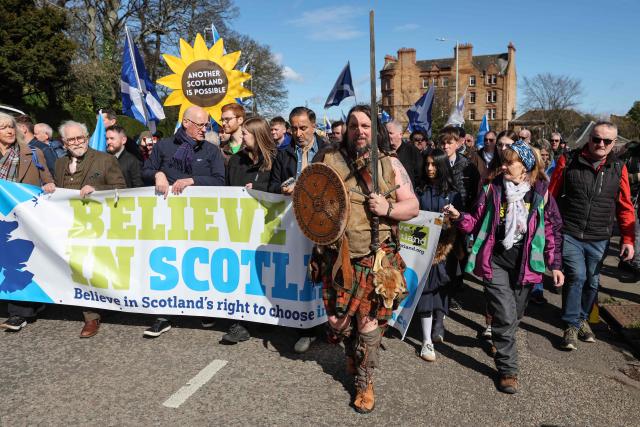 Scottish National Party (SNP) leader John Swinney (3rd L in front) is joined by actor Brian Cox (2nd L) as they carry a banner during a march in support of Scottish independence in Edinburgh on March 28, 2026. (Photo by ROBERT PERRY / AFP)
