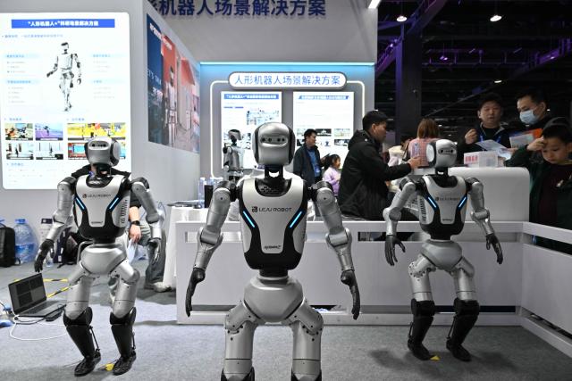 Robots from Leju Robot company are displayed as people visit the Beijing Sci-Fi Carnival in Beijing on March 28, 2026. (Photo by ADEK BERRY / AFP)