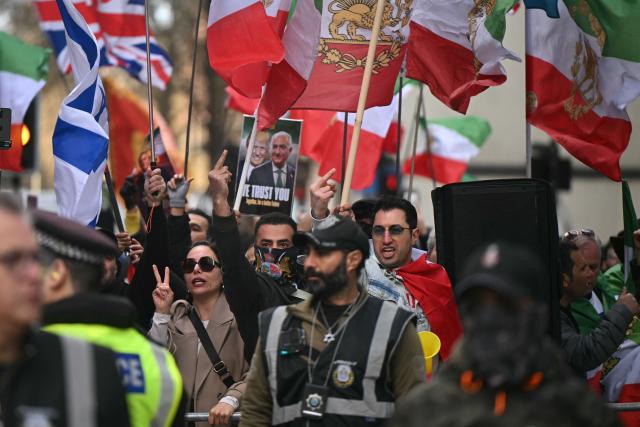 Counter-protesters wave US, Israeli and pre-revolution Iranian flags as a pro-palestinian march organised by the Palestine Coalition passes by, in central London on March 28, 2026.  (Photo by JUSTIN TALLIS / AFP)