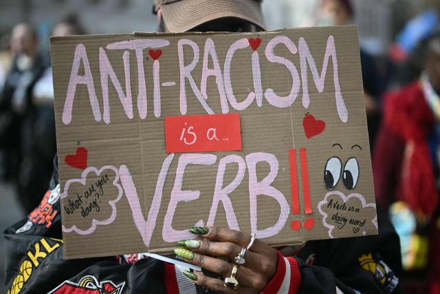 A protester holds a placard during a march against the far right, organised by the Together Alliance, in central London on March 28, 2026. (Photo by JUSTIN TALLIS / AFP)