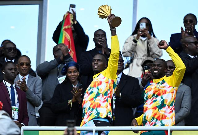 Senegal's goalkeeper #16 Edouard Mendy (L) and Senegal's defender #03 Kalidou Koulibaly pose with The African Cup of Nations trophy ahead of the international friendly football match between Senegal and Peru at the Stade de France in Saint-Denis, north of Paris on March 28, 2026. (Photo by JULIEN DE ROSA / AFP)