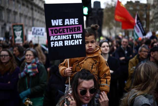 Protesters holding placards gather ahead of speeches after a march against the far right, organised by the Together Alliance, in central London on March 28, 2026. (Photo by Henry NICHOLLS / AFP)