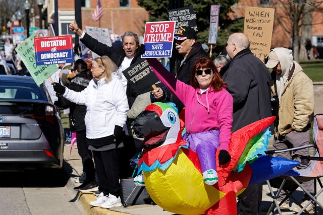 Demonstrators take part in the "No Kings" national day of protest in Howell, Michigan, on March 28, 2026. Nationwide protests against US President Donald Trump are expected Saturday as millions of people vent fury over what they see as his authoritarian bent and other forms of cruel, law-trampling governance. It is the third time in less than a year that Americans will take to the streets as part of a grassroots movement called "No Kings," the most vocal and visual conduit for opposition to Trump since he began his second term in January 2025. (Photo by JEFF KOWALSKY / AFP)