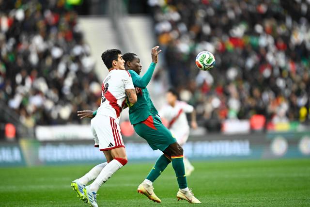 Senegal's forward #11 Nicolas Jackson (R) fights for the ball with Peru's defender #02 Alfonso Barco during the international friendly football match between Senegal and Peru at the Stade de France in Saint-Denis, north of Paris, on March 28, 2026. (Photo by JULIEN DE ROSA / AFP)