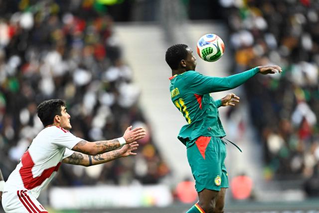 Senegal's forward #11 Nicolas Jackson (R) fights for the ball with Peru's defender #02 Alfonso Barco during the international friendly football match between Senegal and Peru at the Stade de France in Saint-Denis, north of Paris, on March 28, 2026. (Photo by JULIEN DE ROSA / AFP)