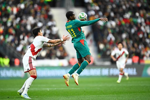 Senegal's forward #11 Nicolas Jackson (R) fights for the ball with Peru's defender #02 Alfonso Barco during the international friendly football match between Senegal and Peru at the Stade de France in Saint-Denis, north of Paris, on March 28, 2026. (Photo by JULIEN DE ROSA / AFP)