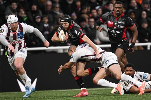 Lyon's French scrum-half Esteban Gonzalez (C) is tackled by Bordeaux-Begles' French scrum-half Maxime Lucu (2R) as he runs with the ball during the French Top14 rugby union match between Lyon Olympique Universitaire Rugby and Union Bordeaux-Begles (UBB) at the Gerland Stadium in Lyon, central-eastern France on March 28, 2026. (Photo by ARNAUD FINISTRE / AFP)