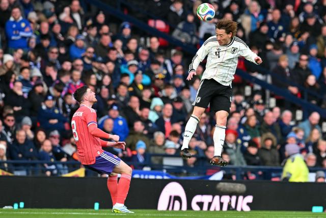 Japan's defender Ayumu Seko (R) wins a header during the friendly International football match between Scotland and Japan at Hampden Park, in Glasgow, on March 28, 2026. (Photo by ANDY BUCHANAN / AFP)