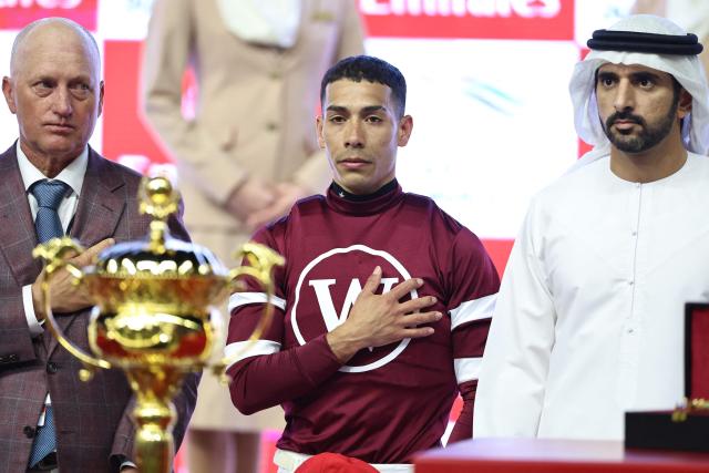 Jockey #2 Jose Ortiz reacts on the podium next to the trophy after winning Race 9 during the Dubai World Cup horse race in Dubai on March 28, 2026. Since the United States and Israel began striking Iran on February 28, Tehran has launched waves of missiles and drones at Gulf states, with more than 2,000 attacks on the UAE alone. (Photo by Fadel SENNA / AFP)