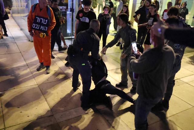 Israeli police arrest a protester from the weekly anti-war demonstration at HaBima Square in Tel Aviv on March 28, 2026 amid safety concerns over possible projectile attacks. The US and Israel launched strikes against Iran on February 28, sparking swift retaliation by the Islamic republic which responded with missile attacks across the region. (Photo by Ilia YEFIMOVICH / AFP)