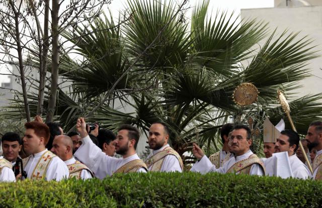 A Christian Syriac Orthodox priest leads a Palm Sunday service at the Queen of Peace  Church in Arbil, the capital of the autonomous Kurdish region of northern Iraq, on March 28, 2026. (Photo by Safin HAMID / AFP)
