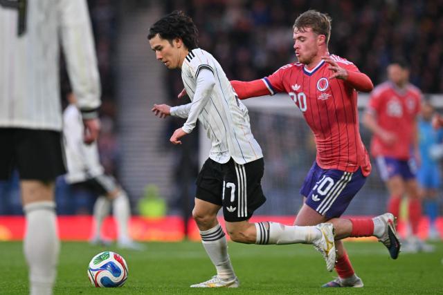 Japan's midfielder Ao Tanaka (L) runs away from Scotland's striker #20 Tommy Conway (R) during the friendly International football match between Scotland and Japan at Hampden Park, in Glasgow, on March 28, 2026. (Photo by ANDY BUCHANAN / AFP)