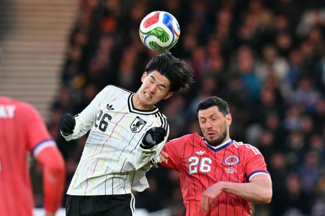 Japan's forward Keisuke Goto (L) vies with Scotland's defender #16 Scott McKenna (R) during the friendly International football match between Scotland and Japan at Hampden Park, in Glasgow, on March 28, 2026. (Photo by ANDY BUCHANAN / AFP)