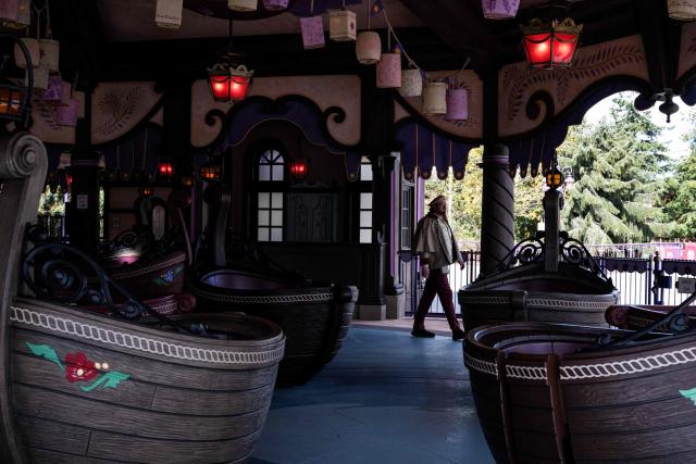 An employee walks through the 'Raiponce Tangled Spin' attraction at the new Disney Park expansion Disney Adventure World ahead of its opening at Disneyland Paris in Marne-la-Vallee, east of Paris on March 28, 2026. 'World of Frozen' will open on March 29, 2026. (Photo by Blanca CRUZ / AFP)