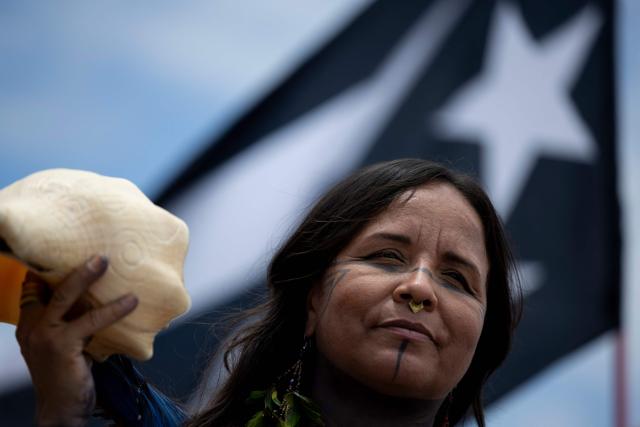 A demonstrator with face paint holds a conch shell during the "No Kings" national day of protest that included opposition to the proposed Esencia coastal development project in San Juan, Puerto Rico, on March 28, 2026. Nationwide protests against US President Donald Trump are expected Saturday as millions of people vent fury over what they see as his authoritarian bent and other forms of cruel, law-trampling governance. It is the third time in less than a year that Americans will take to the streets as part of a grassroots movement called "No Kings," the most vocal and visual conduit for opposition to Trump since he began his second term in January 2025. (Photo by Ricardo ARDUENGO / AFP)