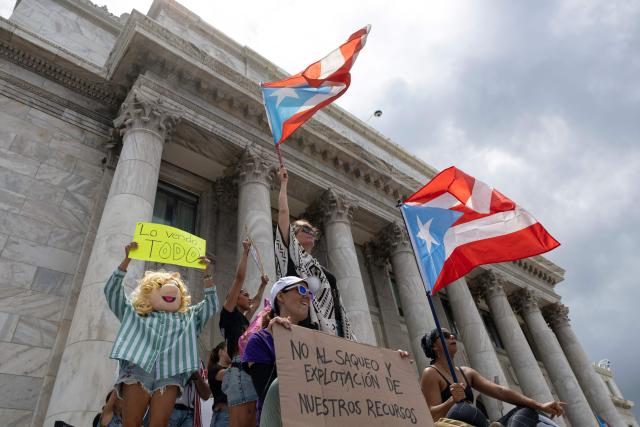 Demonstrators hold Puerto Rican flags and protest signs in front of the Capitol during the "No Kings" national day of protest that included opposition to the proposed Esencia coastal development project in San Juan, Puerto Rico, on March 28, 2026. Nationwide protests against US President Donald Trump are expected Saturday as millions of people vent fury over what they see as his authoritarian bent and other forms of cruel, law-trampling governance. It is the third time in less than a year that Americans will take to the streets as part of a grassroots movement called "No Kings," the most vocal and visual conduit for opposition to Trump since he began his second term in January 2025. (Photo by Ricardo ARDUENGO / AFP)