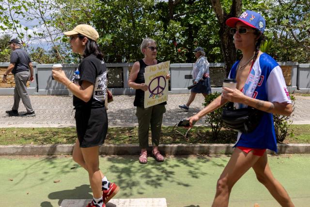 A woman holds a sign during the "No Kings" national day of protest that included opposition to the proposed Esencia coastal development project in San Juan, Puerto Rico, on March 28, 2026. Nationwide protests against US President Donald Trump are expected Saturday as millions of people vent fury over what they see as his authoritarian bent and other forms of cruel, law-trampling governance. It is the third time in less than a year that Americans will take to the streets as part of a grassroots movement called "No Kings," the most vocal and visual conduit for opposition to Trump since he began his second term in January 2025. (Photo by Ricardo ARDUENGO / AFP)