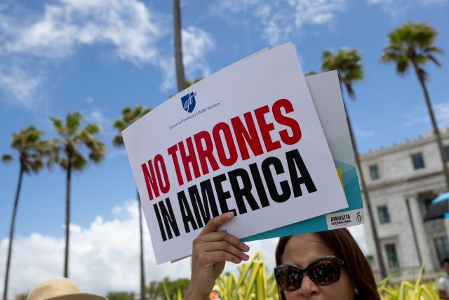 A person holds a sign reading "no thrones in America" during the "No Kings" national day of protest that included opposition to the proposed Esencia coastal development project in San Juan, Puerto Rico, on March 28, 2026. Nationwide protests against US President Donald Trump are expected Saturday as millions of people vent fury over what they see as his authoritarian bent and other forms of cruel, law-trampling governance. It is the third time in less than a year that Americans will take to the streets as part of a grassroots movement called "No Kings," the most vocal and visual conduit for opposition to Trump since he began his second term in January 2025. (Photo by Ricardo ARDUENGO / AFP)