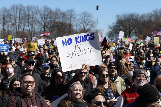 People hold signs as they rally at Grant Park during the "No Kings" national day of protest in Chicago on March 28, 2026. Nationwide protests against US President Donald Trump are expected Saturday as millions of people vent fury over what they see as his authoritarian bent and other forms of cruel, law-trampling governance. It is the third time in less than a year that Americans will take to the streets as part of a grassroots movement called "No Kings," the most vocal and visual conduit for opposition to Trump since he began his second term in January 2025. (Photo by KAMIL KRZACZYNSKI / AFP)