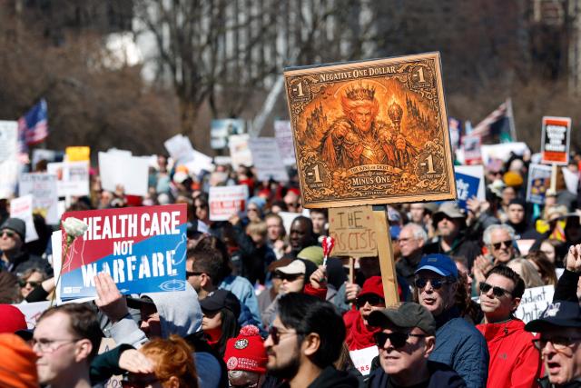 A person holds a sign reading "the king of debt" as they rally at Grant Park during the "No Kings" national day of protest in Chicago on March 28, 2026. Nationwide protests against US President Donald Trump are expected Saturday as millions of people vent fury over what they see as his authoritarian bent and other forms of cruel, law-trampling governance. It is the third time in less than a year that Americans will take to the streets as part of a grassroots movement called "No Kings," the most vocal and visual conduit for opposition to Trump since he began his second term in January 2025. (Photo by KAMIL KRZACZYNSKI / AFP)