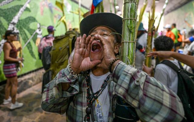 A palm frond picker shouts slogans at the Waraira Repano National Park on the eve of Palm Sunday in Caracas on March 28, 2026. Hundreds of palm frond pickers descend from El Avila hill after spending a week collecting the fronds that will be used in the Palm Sunday and Holy Week masses. (Photo by Maryorin Mendez / AFP)