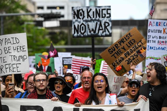 People holding signs march downtown during the "No Kings" national day of protest in Houston on March 28, 2026. Nationwide protests against US President Donald Trump are expected Saturday as millions of people vent fury over what they see as his authoritarian bent and other forms of cruel, law-trampling governance. It is the third time in less than a year that Americans will take to the streets as part of a grassroots movement called "No Kings," the most vocal and visual conduit for opposition to Trump since he began his second term in January 2025. (Photo by RONALDO SCHEMIDT / AFP)