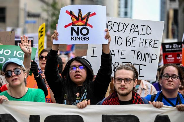 People holding signs march downtown during the "No Kings" national day of protest in Houston on March 28, 2026. Nationwide protests against US President Donald Trump are expected Saturday as millions of people vent fury over what they see as his authoritarian bent and other forms of cruel, law-trampling governance. It is the third time in less than a year that Americans will take to the streets as part of a grassroots movement called "No Kings," the most vocal and visual conduit for opposition to Trump since he began his second term in January 2025. (Photo by RONALDO SCHEMIDT / AFP)