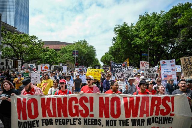 People holding signs march downtown during the "No Kings" national day of protest in Houston on March 28, 2026. Nationwide protests against US President Donald Trump are expected Saturday as millions of people vent fury over what they see as his authoritarian bent and other forms of cruel, law-trampling governance. It is the third time in less than a year that Americans will take to the streets as part of a grassroots movement called "No Kings," the most vocal and visual conduit for opposition to Trump since he began his second term in January 2025. (Photo by RONALDO SCHEMIDT / AFP)