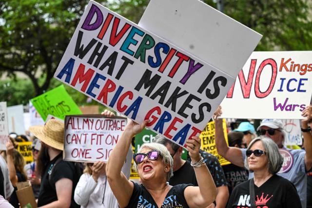 People holding signs march downtown during the "No Kings" national day of protest in Houston on March 28, 2026. Nationwide protests against US President Donald Trump are expected Saturday as millions of people vent fury over what they see as his authoritarian bent and other forms of cruel, law-trampling governance. It is the third time in less than a year that Americans will take to the streets as part of a grassroots movement called "No Kings," the most vocal and visual conduit for opposition to Trump since he began his second term in January 2025. (Photo by RONALDO SCHEMIDT / AFP)