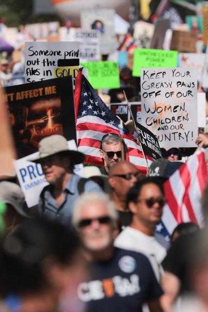 Protestors holding signs begin their march from Los Angeles City Hall during the "No Kings" national day of protest in Los Angeles on March 28, 2026. Nationwide protests against US President Donald Trump are expected Saturday as millions of people vent fury over what they see as his authoritarian bent and other forms of cruel, law-trampling governance. It is the third time in less than a year that Americans will take to the streets as part of a grassroots movement called "No Kings," the most vocal and visual conduit for opposition to Trump since he began his second term in January 2025. (Photo by Etienne Laurent / AFP)