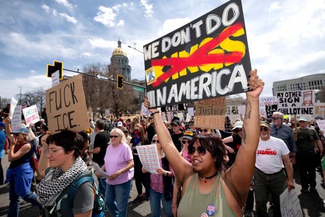 Demonstrators hold signs as they march during the "No Kings" national rally in Denver, Colorado on March 28, 2026. Nationwide protests against US President Donald Trump are expected Saturday as millions of people vent fury over what they see as his authoritarian bent and other forms of cruel, law-trampling governance. It is the third time in less than a year that Americans will take to the streets as part of a grassroots movement called "No Kings," the most vocal and visual conduit for opposition to Trump since he began his second term in January 2025. (Photo by Jason Connolly / AFP)