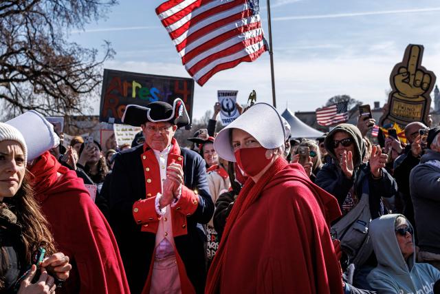 Demonstrators, including activists dressed in US Revolutionary War-era uniforms and as characters from The Handmaid's Tale, gather during a "No Kings" national day of protest rally outside the Minnesota State Capitol on March 28, 2026, in St. Paul, Minnesota. Nationwide protests against US President Donald Trump are expected Saturday as millions of people vent fury over what they see as his authoritarian bent and other forms of cruel, law-trampling governance. It is the third time in less than a year that Americans will take to the streets as part of a grassroots movement called "No Kings," the most vocal and visual conduit for opposition to Trump since he began his second term in January 2025. (Photo by Kerem YUCEL / AFP)