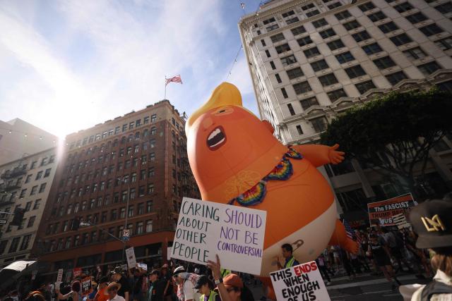 A giant inflatable Donald Trump ballon is seen while protestors march during the "No Kings" national day of protest in Los Angeles on March 28, 2026. Nationwide protests against US President Donald Trump are expected Saturday as millions of people vent fury over what they see as his authoritarian bent and other forms of cruel, law-trampling governance. It is the third time in less than a year that Americans will take to the streets as part of a grassroots movement called "No Kings," the most vocal and visual conduit for opposition to Trump since he began his second term in January 2025. (Photo by Etienne Laurent / AFP)