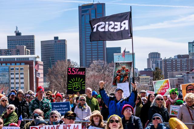 People hold signs and flags as they gather outside the Minnesota State Capitol during the "No Kings" national day of protest in Saint Paul, Minnesota, on March 28, 2026. Nationwide protests against US President Donald Trump are expected Saturday as millions of people vent fury over what they see as his authoritarian bent and other forms of cruel, law-trampling governance. It is the third time in less than a year that Americans will take to the streets as part of a grassroots movement called "No Kings," the most vocal and visual conduit for opposition to Trump since he began his second term in January 2025. (Photo by Kerem YUCEL / AFP)