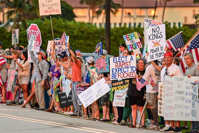 Protesters hold signs and flags near US President Donald Trump's Mar-a-Lago resort during the "No Kings" national day of protest, in Palm Beach, Florida, on May 28, 2026. Nationwide protests against US President Donald Trump are expected Saturday as millions of people vent fury over what they see as his authoritarian bent and other forms of cruel, law-trampling governance. It is the third time in less than a year that Americans will take to the streets as part of a grassroots movement called "No Kings," the most vocal and visual conduit for opposition to Trump since he began his second term in January 2025. (Photo by Giorgio VIERA / AFP)