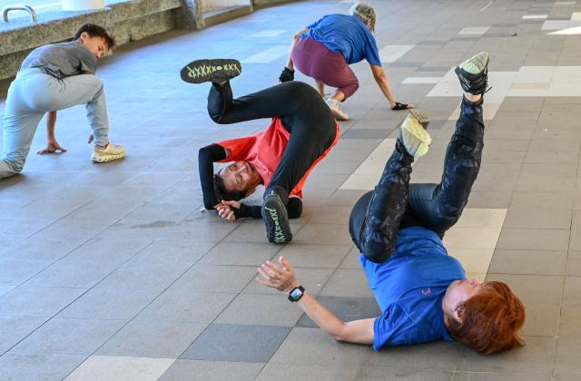This photograph taken on March 17, 2026 shows Singaporean elders warming up before a parkour training session in Singapore. This is "geriatric parkour", where around 20 retirees learned to tackle a series of relatively demanding exercises, building their agility and enjoying a sense of camaraderie. (Photo by Roslan RAHMAN / AFP) / To go with "Singapore-Ageism" Focus by Martin ABBUGAO