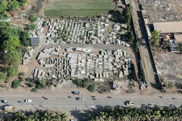 An aerial view shows ceramic tiles stacked at an open field in Morbi on March 26, 2026 amid propane gas supply constraints and global energy crisis owing to the Middle East war. Blazing-hot kilns in India's $6.5 billion ceramics production hub employing hundreds of thousands of people have gone cold, shut down in an energy crunch sparked by the US-Israeli strikes on Iran. (Photo by Indranil MUKHERJEE / AFP)