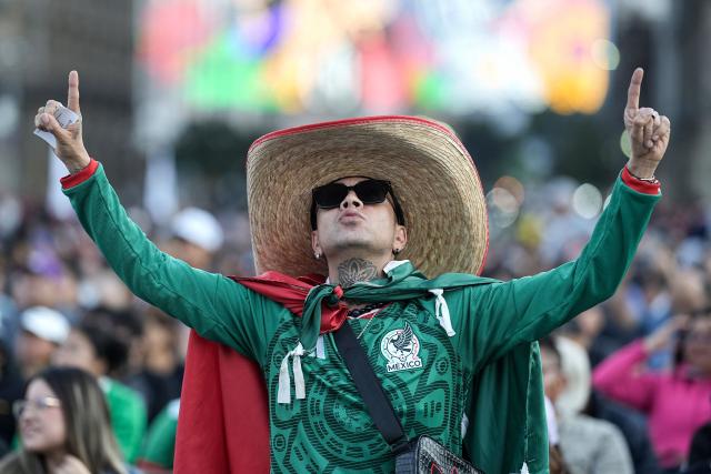 A Mexican fan cheers for his team watching a broadcast of the friendly football match between Mexico and Portugal at Zocalo square in Mexico City on March 28, 2026. (Photo by Heptor ARJONA / AFP)