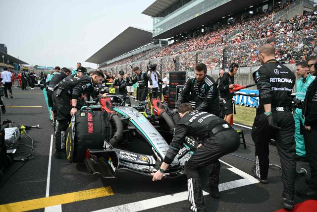 Mercedes crew make last-minute preparations on the car of Italian driver Kimi Antonelli, who is in pole position, before the start of the Formula One Japanese Grand Prix at the Suzuka circuit in Suzuka, Mie prefecture on March 29, 2026. (Photo by ANDREW CABALLERO-REYNOLDS / AFP)