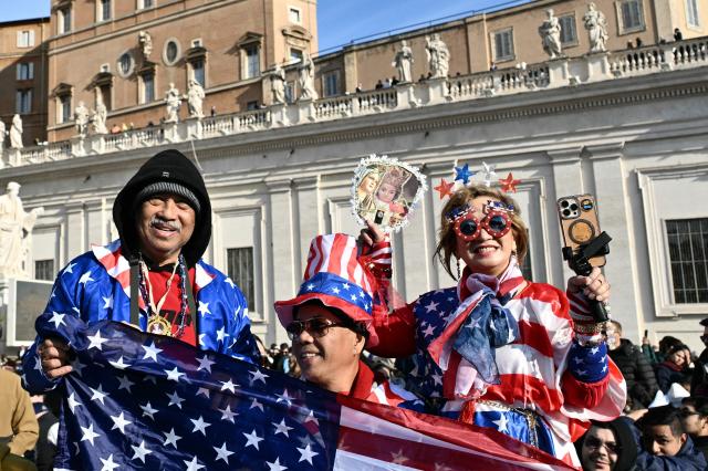 Worshippers hold US flags as they arrive to attend a mass for Palm Sunday by Pope Leo XIV at St Peter's square in the Vatican on March 29, 2026. (Photo by Tiziana FABI / AFP)