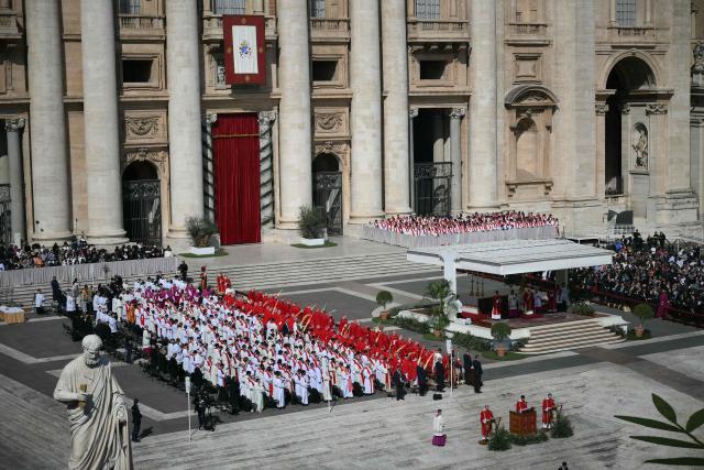 People attend a mass for Palm Sunday led by Pope Leo XIV at St Peter's square in the Vatican on March 29, 2026. (Photo by Marco BERTORELLO / AFP)