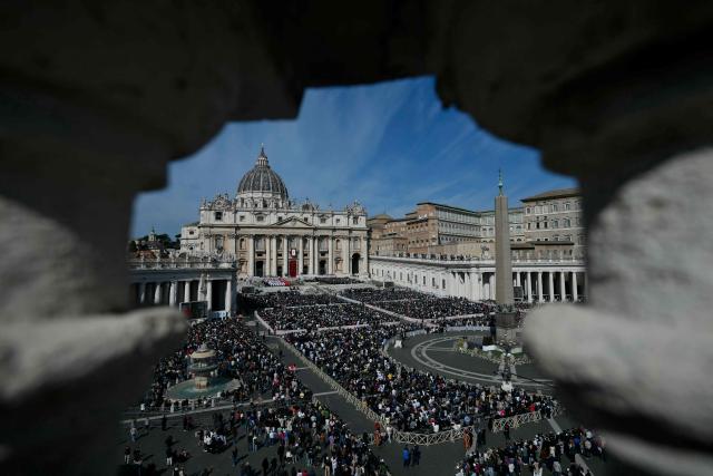 People attend a mass for Palm Sunday led by Pope Leo XIV at St Peter's square in the Vatican on March 29, 2026. (Photo by Marco BERTORELLO / AFP)