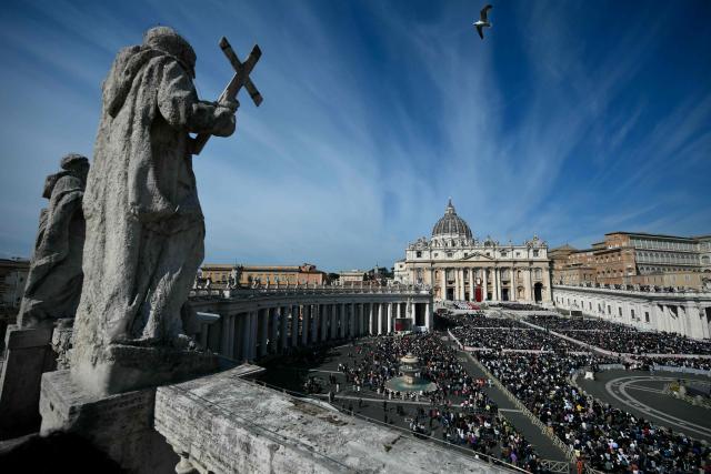 TOPSHOT - People attend a mass for Palm Sunday led by Pope Leo XIV at St Peter's square in the Vatican on March 29, 2026. (Photo by Marco BERTORELLO / AFP)
